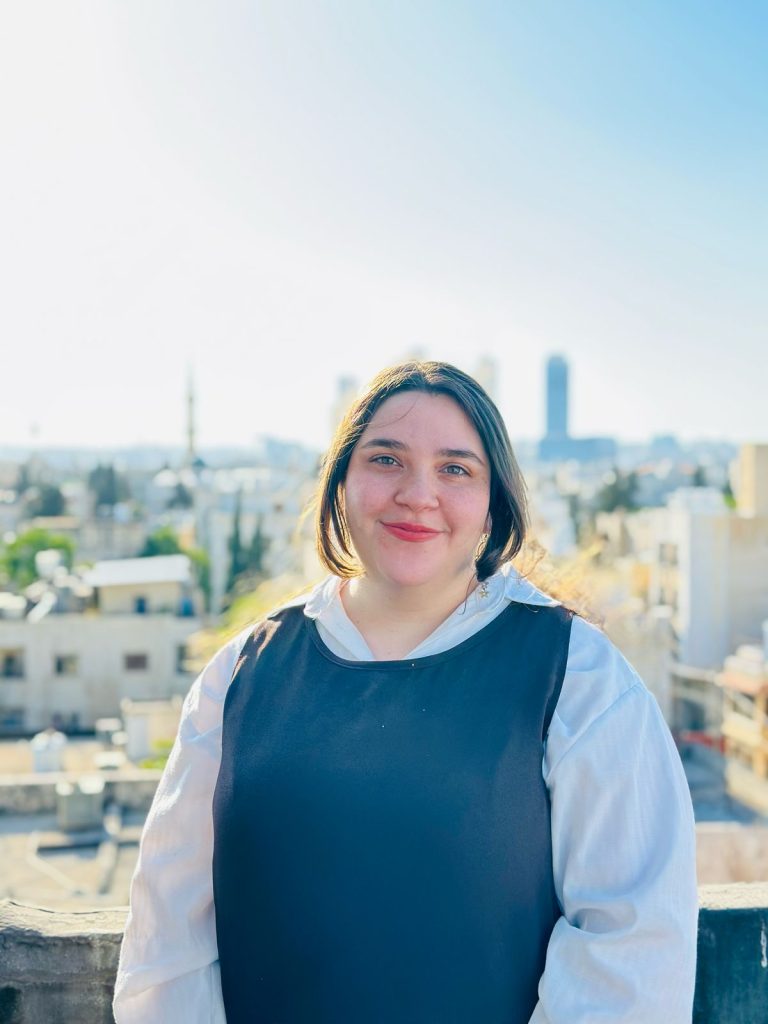 A portrait of Teacher Sanabel smiling, an Arabic language teacher at Misbah Center, Jordan.