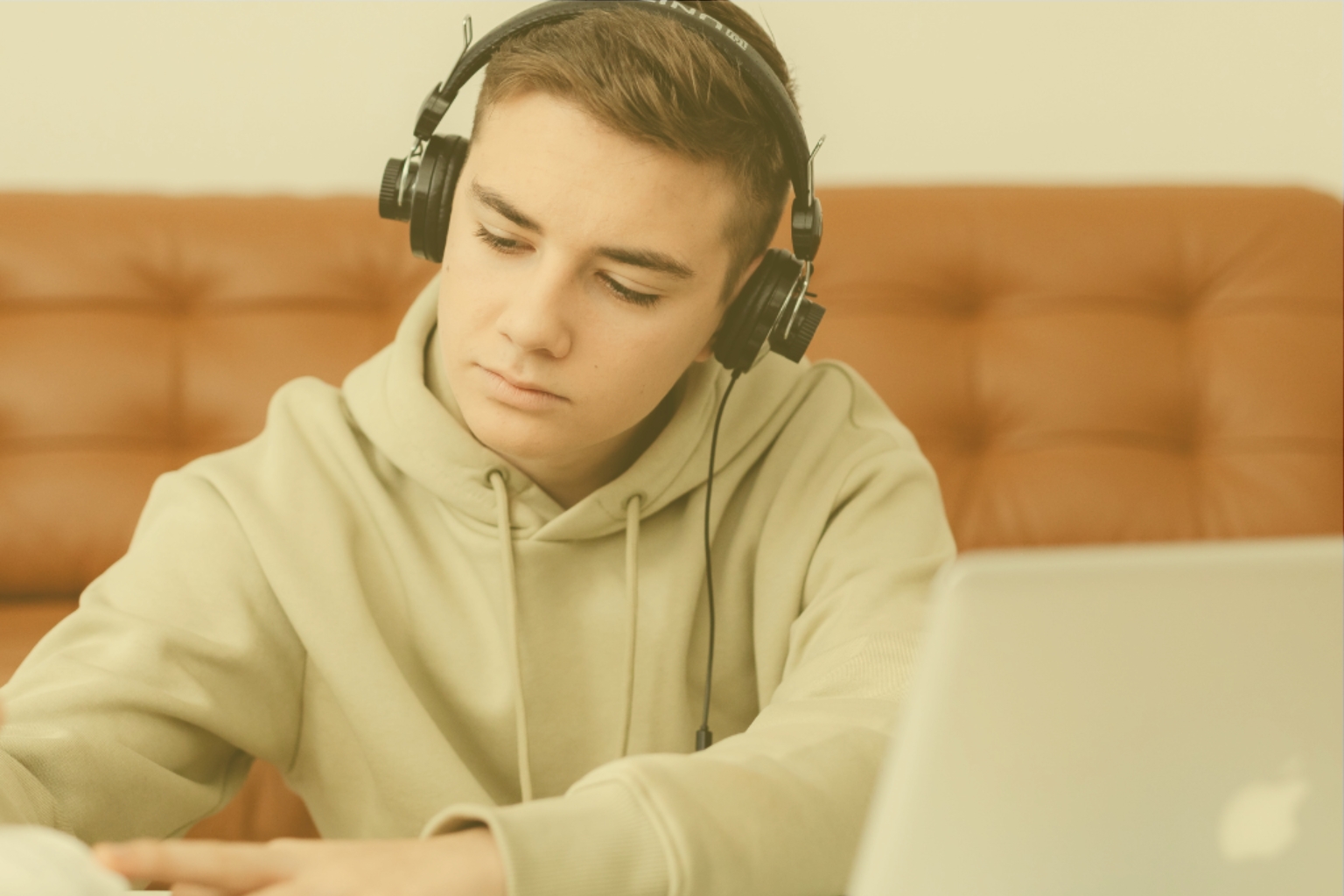 Student wearing headphones attending an interactive online Arabic language class at Misbah Center
