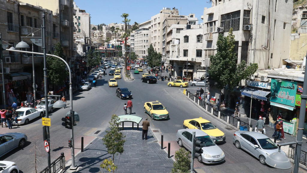 Straße in der Innenstadt von Amman mit arabischen Ladenschildern und gelben Taxis